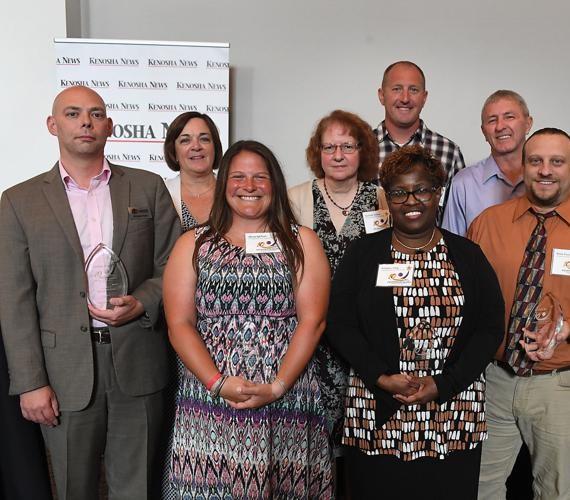 Group photo of the 2018 Kenosha News 10 Exceptional People awards, Michael Polzin at far left holding a glass award.